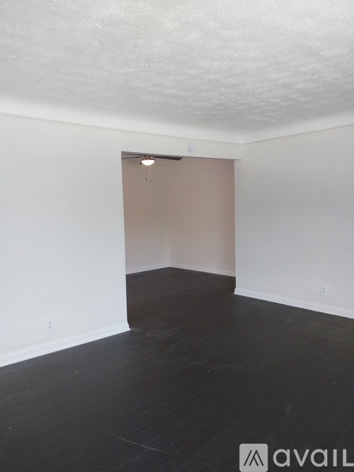 A room with a wooden floor and a white wall.