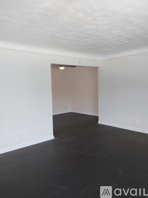 A room with a wooden floor and a white wall.