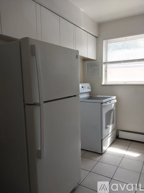 A white refrigerator is in a kitchen with a washer and dryer.