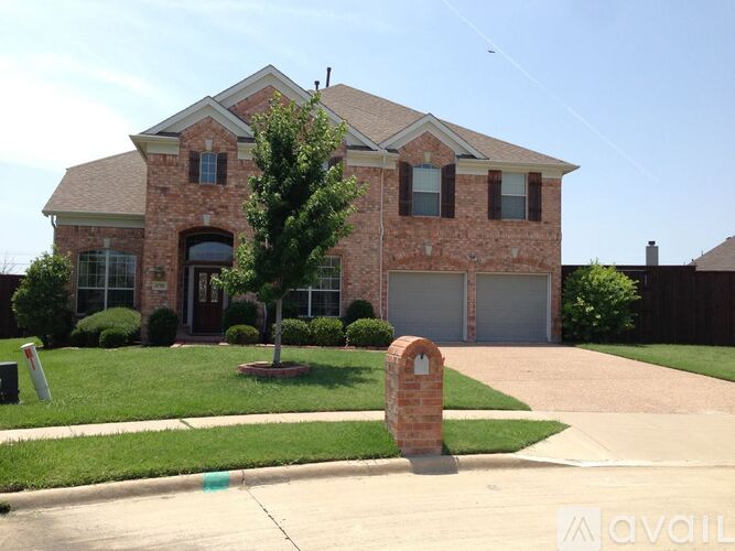 A brick house with a large front yard and a driveway.