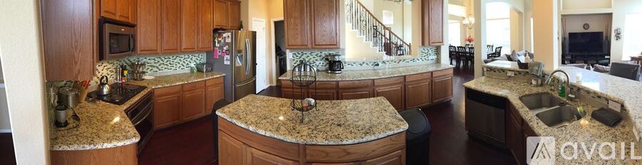 A kitchen with granite countertops and wooden cabinets.