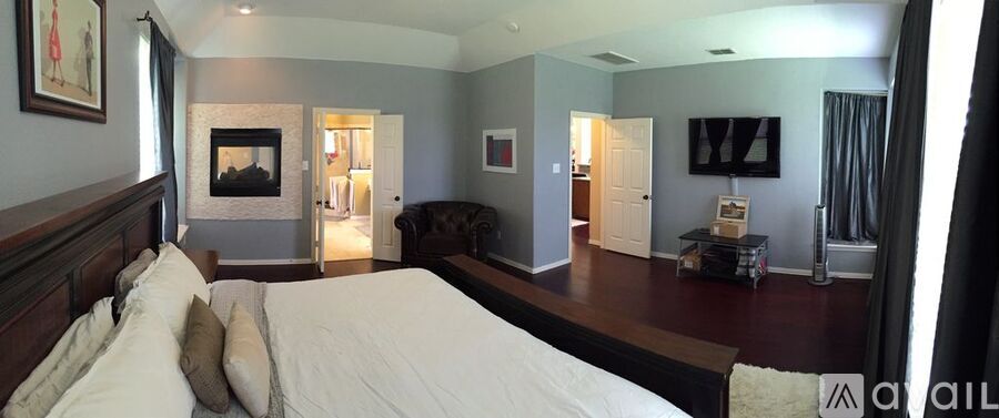 A bedroom with a large bed and a fireplace.