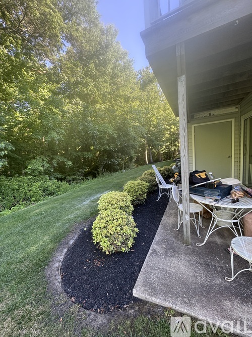 A backyard with a table and chairs and a small garden.