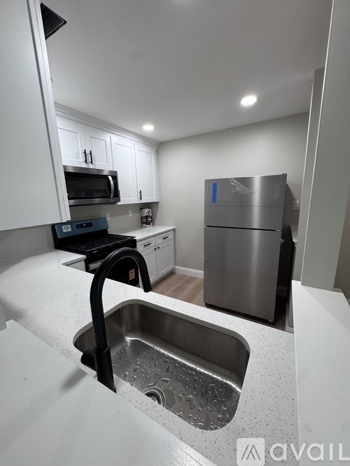 A kitchen with a sink and a refrigerator.