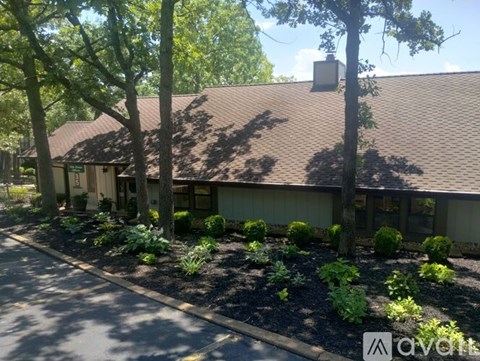 A building with a brown roof and a parking lot in front.