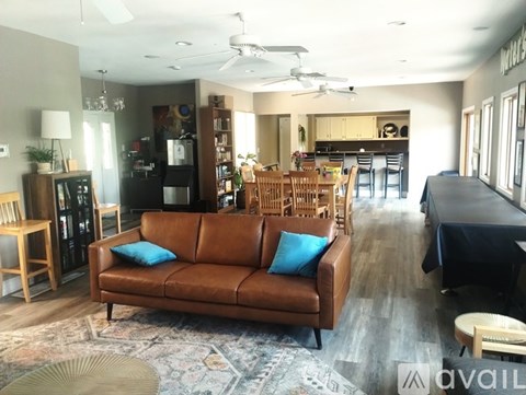 A living room with a brown couch and a rug.