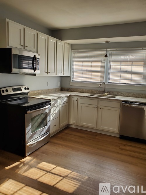 A kitchen with white cabinets and a black stove top oven.