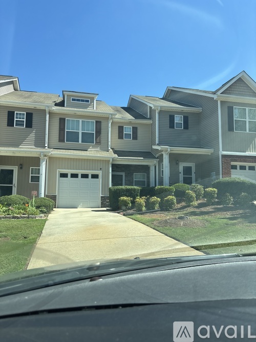 A row of houses with a car in the foreground.