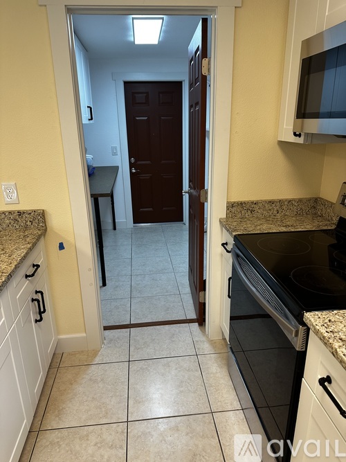 A kitchen with a black oven and white cabinets.