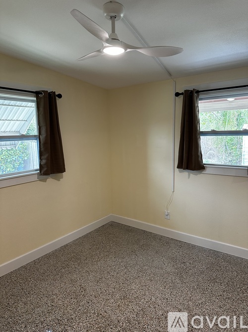 A room with a ceiling fan and carpeted floor.