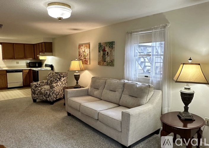 A living room with a couch, chair, and lamp.