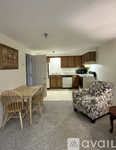 A kitchen area with a table and chairs.