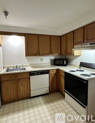 A kitchen with wooden cabinets and white appliances.