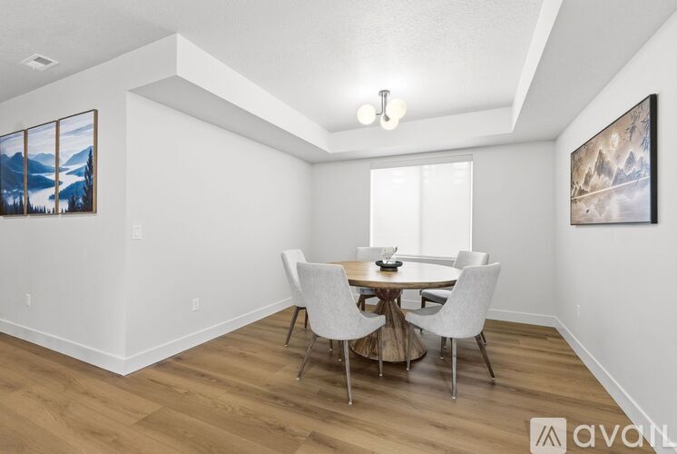 A dining room with a table and chairs.