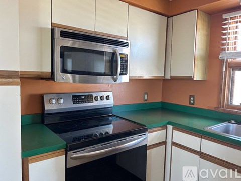 A kitchen with a black stove and microwave above a black oven.
