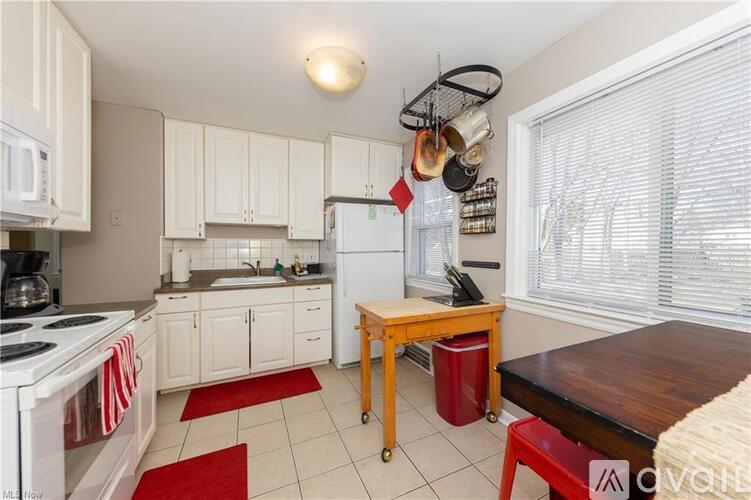 A kitchen with white cabinets and a wooden island.