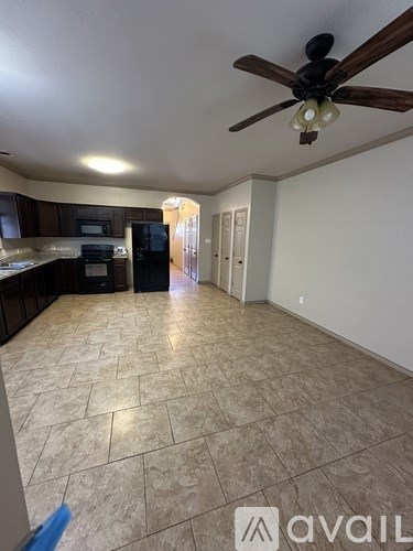 A kitchen with tile flooring and a ceiling fan.