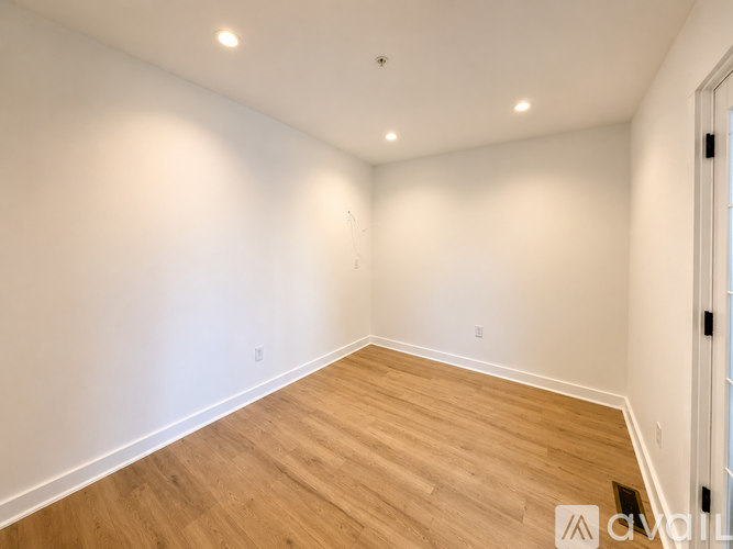 A room with wooden flooring and white walls.