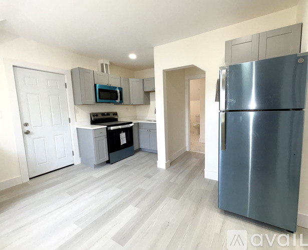 A kitchen with a refrigerator, microwave, oven, and cabinets.