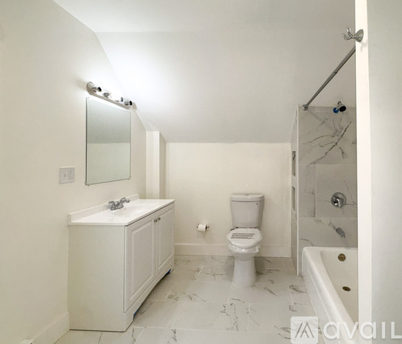A white bathroom with a toilet, sink, and bathtub.