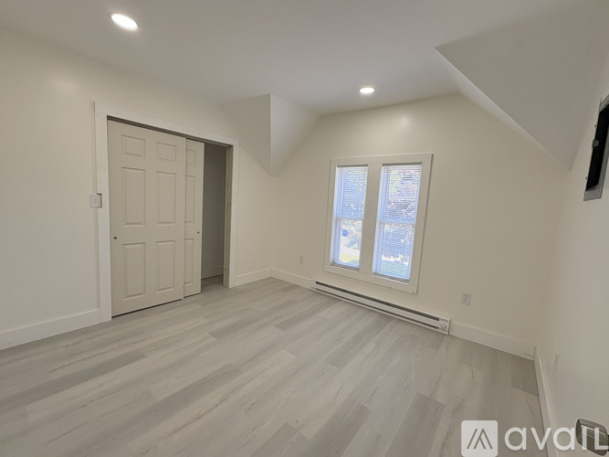 A room with a door and a window with a view of a street.