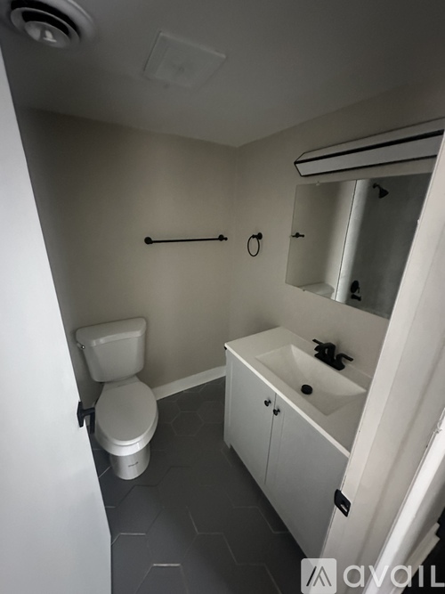 A white toilet and sink in a small bathroom.
