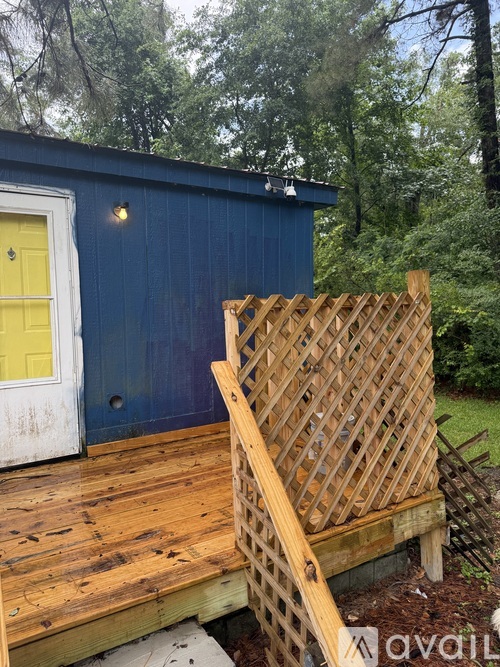 A wooden lattice fence in front of a blue building.