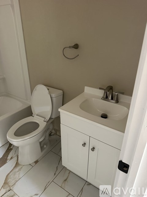 A white toilet and sink in a small bathroom.