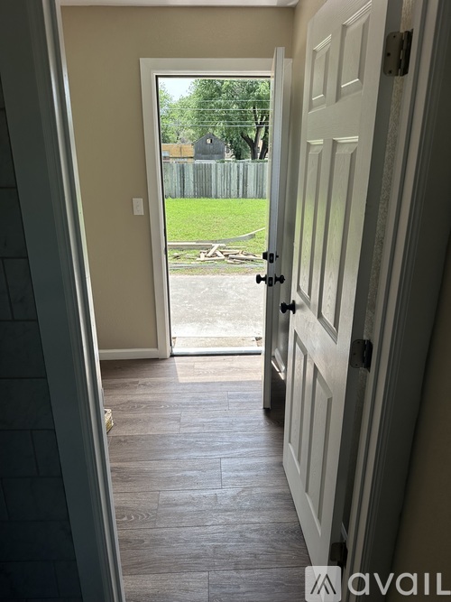A hallway with a door leading to a backyard.