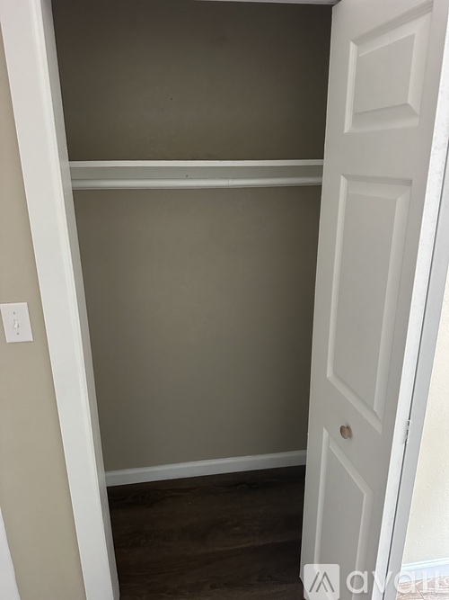 A white door is open to a room with a grey wall.