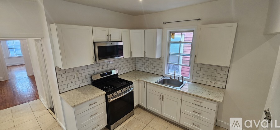 A kitchen with white cabinets and a black stove top oven.