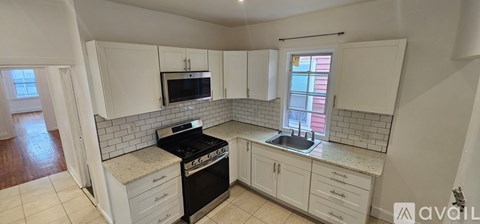 A kitchen with white cabinets and a black stove top oven.