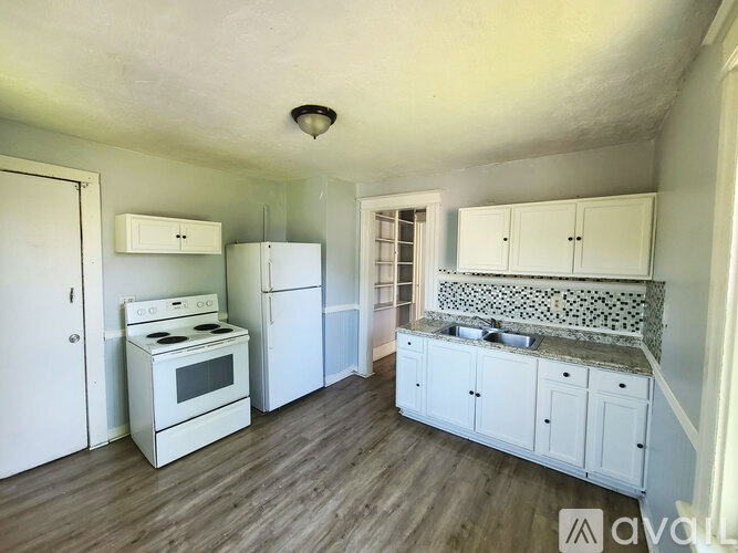 A kitchen with white appliances and cabinets.