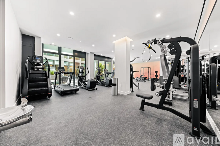 A gym with a variety of equipment including treadmills, weights, and exercise machines.
