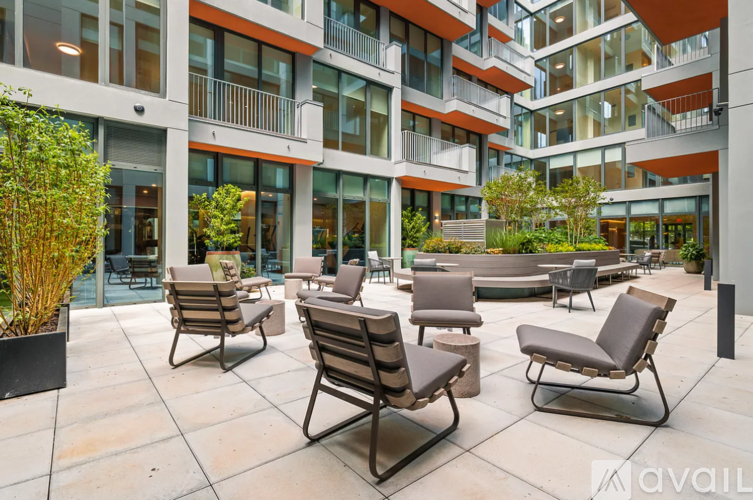 A patio with chairs and a table in front of a building.