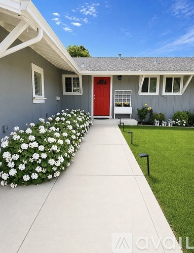 A house with a red door and a white front yard.