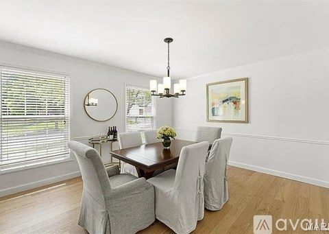 A dining room with a wooden table and chairs.