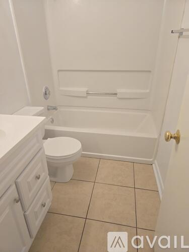 A white toilet sits in a bathroom next to a white sink.