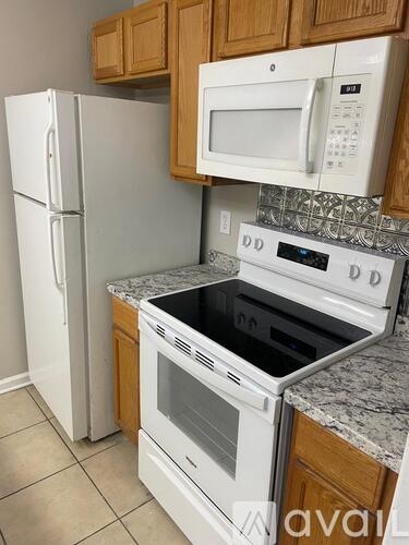 A kitchen with a white refrigerator, a white microwave, and a white oven.