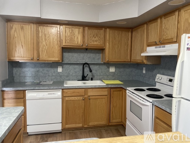 A kitchen with wooden cabinets and white appliances.