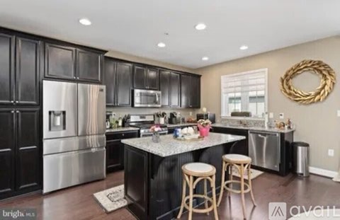A kitchen with black cabinets and stainless steel appliances.