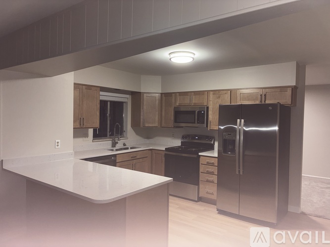 A kitchen with a white counter top and stainless steel appliances.