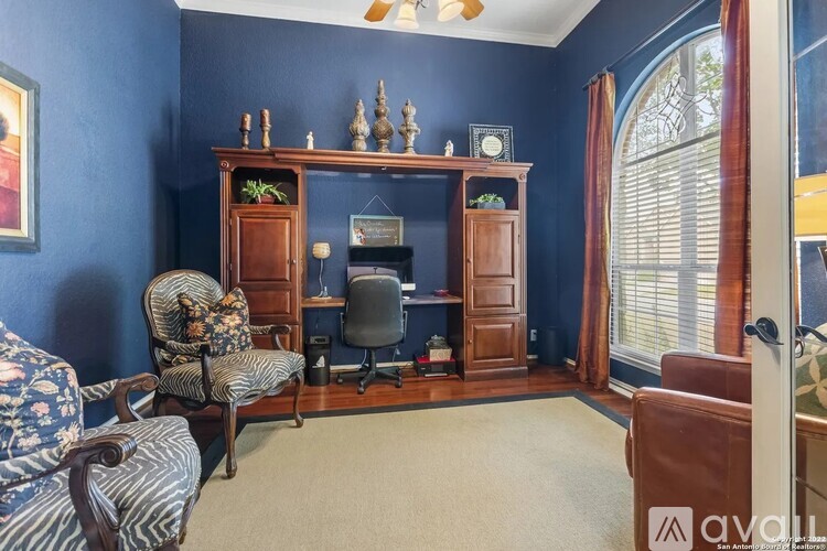 A room with a blue wall and a wooden bookcase.