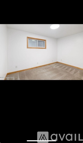 A room with a window and a wooden floor.