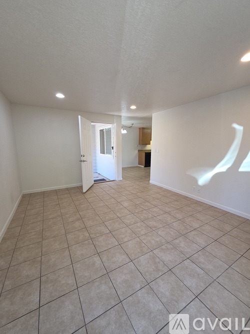 A room with a tiled floor and a doorway leading to another room.