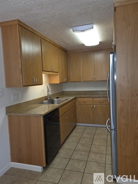 A kitchen with wooden cabinets and a granite countertop.