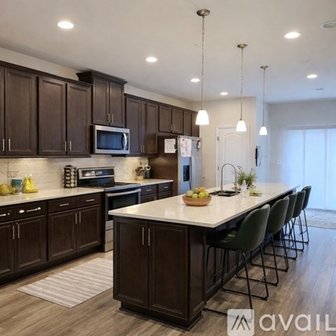 A kitchen with dark brown cabinets and a white island.