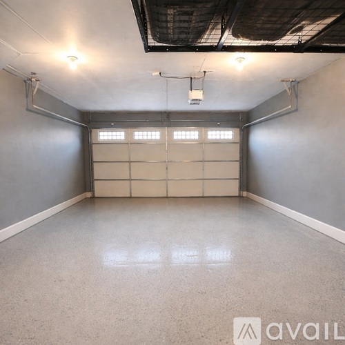 A spacious garage with a concrete floor and white walls.