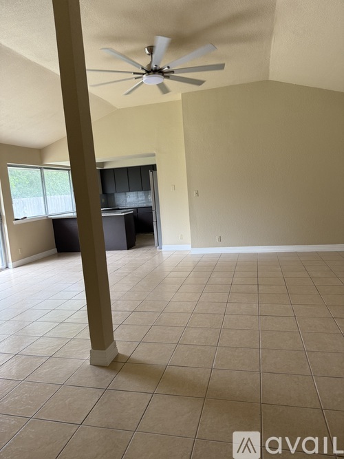 A room with a ceiling fan and tile flooring.