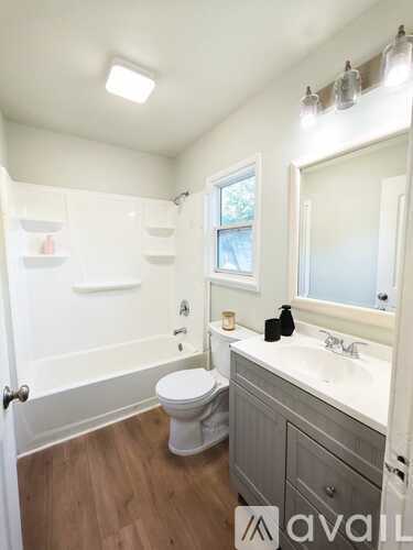 A bathroom with a toilet, sink, and mirror.